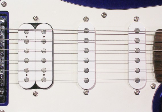 這把吉他則是另一個大廠牌 Fender 的設計。可以看到它便是所謂「單、單、雙」，三組拾音器的設計。若是一把琴上裝設了超過一組拾音器，琴身上便會有旋鈕可以選擇，是要使用哪一段拾音器所接收到的聲音。單線圈的拾音器一般會創造出比較清脆嘹亮的音色。 圖片來源：Wikipedia